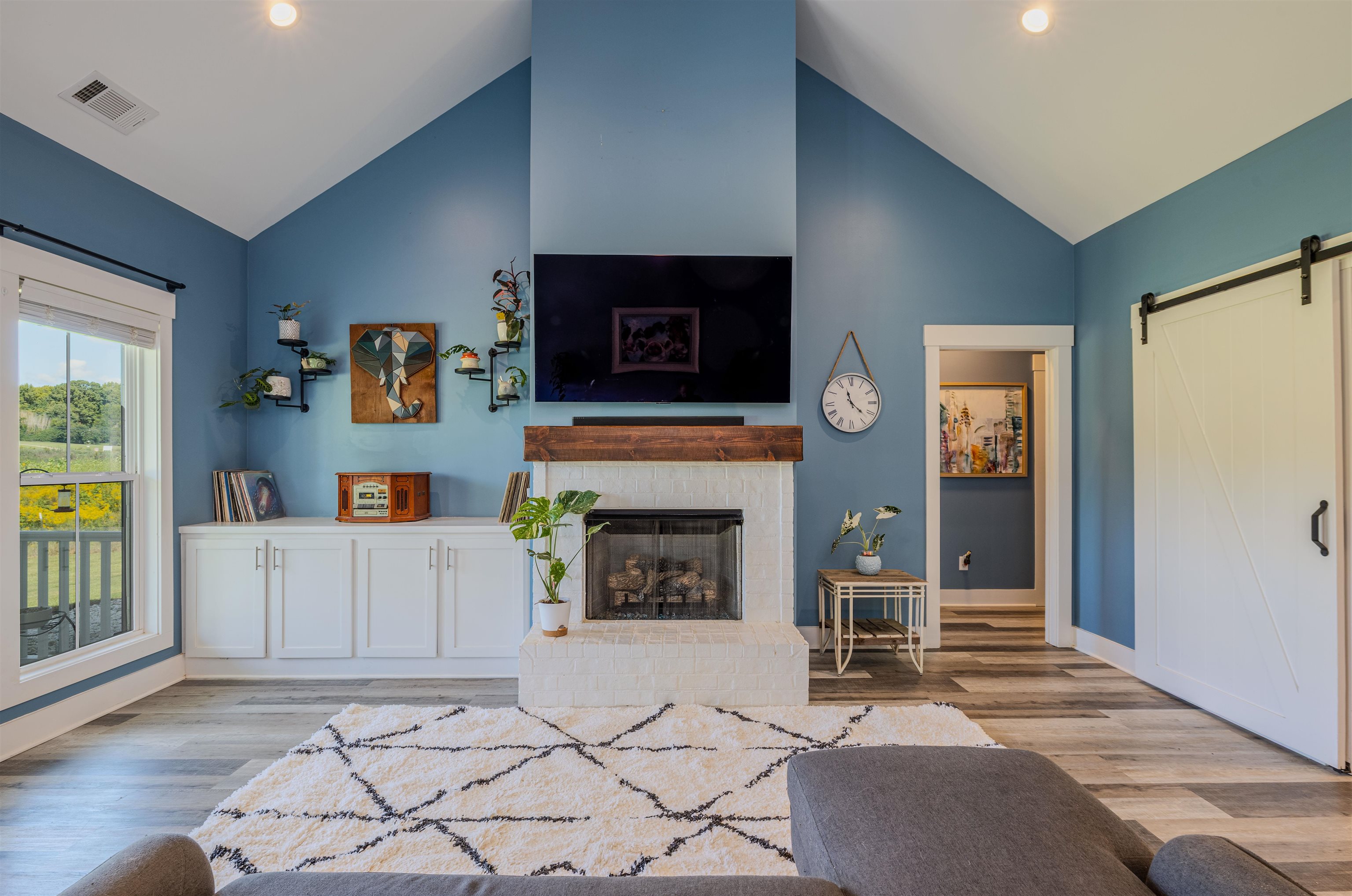 3090 Marshall Road Munford, TN 38058 - Photo 7 of 27 Living area featuring a barn door, light wood-type flooring, a high ceiling, a fireplace, and recessed lighting