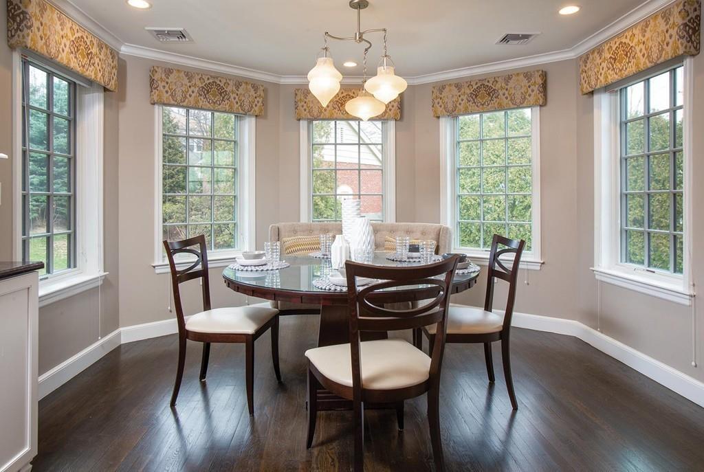 101 Blake Road Brookline, MA 02445 - Photo 11 of 28 a dining room with wooden floor a chandelier a glass table and chairs