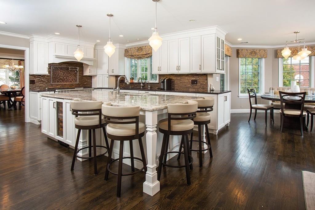 101 Blake Road Brookline, MA 02445 - Photo 10 of 28 a kitchen with stainless steel appliances a dining table chairs stove and white cabinets