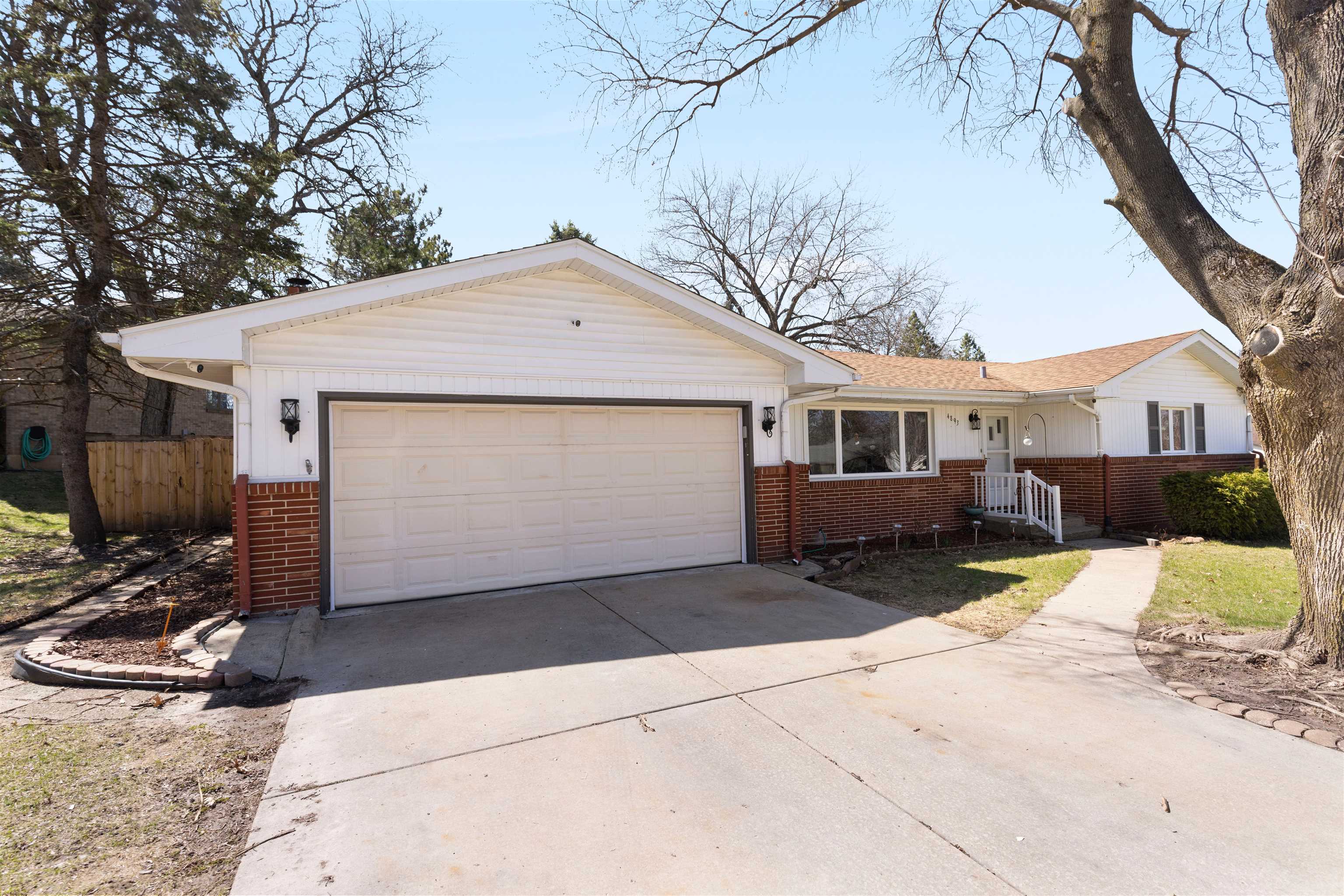 4893 Braewild Road Rockford, IL 61107 - Photo 1 of 21 a front view of a house with a yard and parking space
