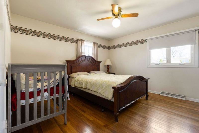 4893 Braewild Road Rockford, IL 61107 - Photo 10 of 21 a bedroom with a bed stairs and a chandelier