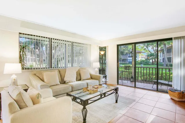 a living room with furniture and a floor to ceiling window