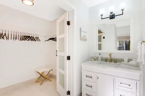 a bathroom with a granite countertop sink a mirror and a toilet