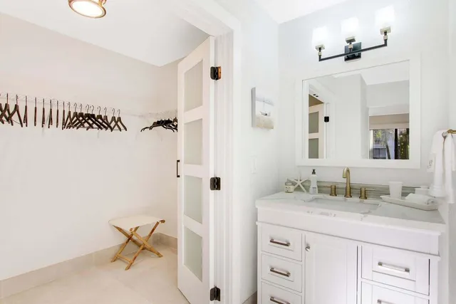 a bathroom with a granite countertop sink a mirror and a toilet