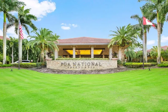 a view of a house with a big yard and palm trees