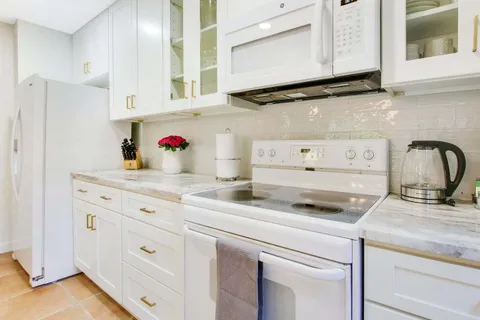 a kitchen with cabinets appliances a sink and a counter top space