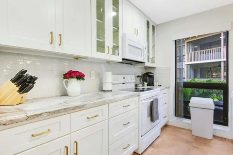a kitchen with white cabinets and sink