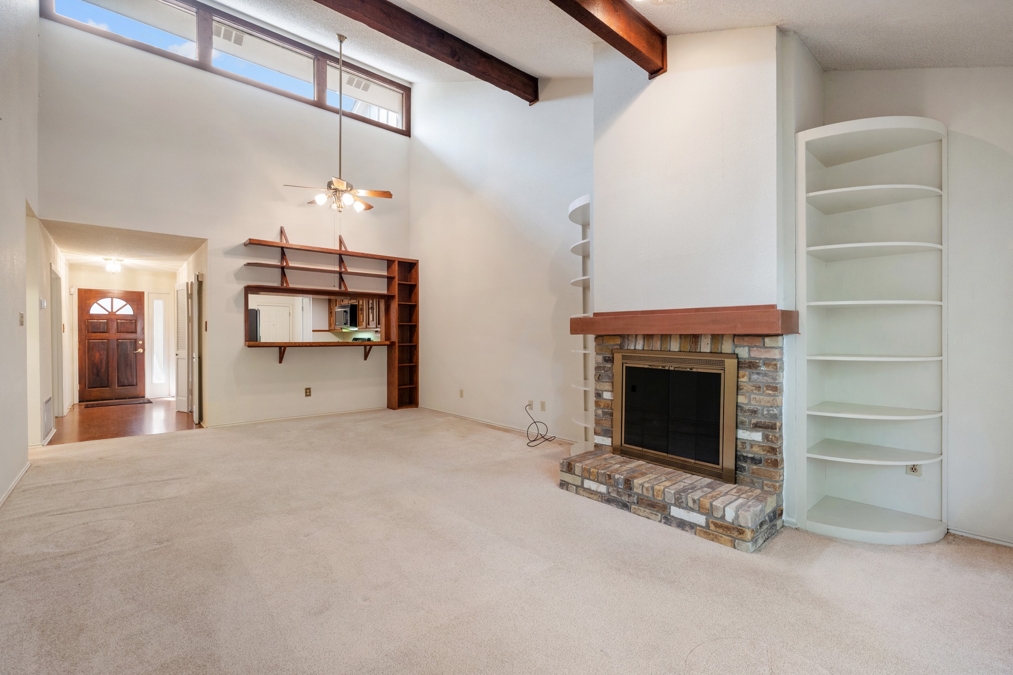 8318 Bent Tree Road Austin, TX 78759 - Photo 19 of 37 The open-concept living area stands out with its vaulted, wood-beamed ceiling and a beautiful brick fireplace