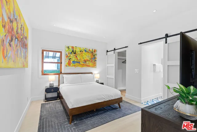 a bedroom with a bed and a painting on the wall