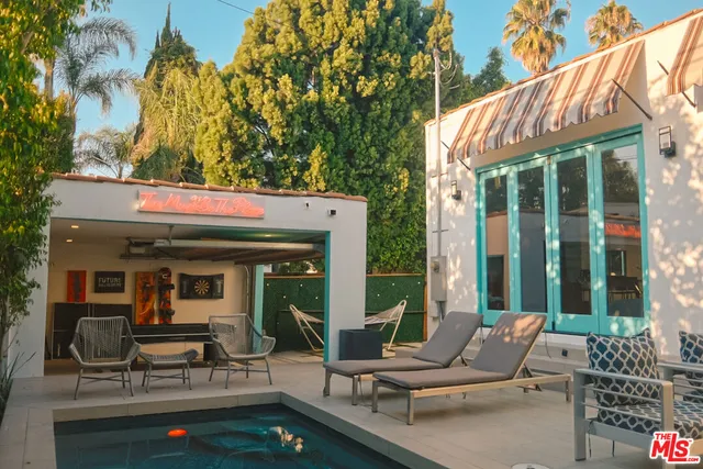 a view of a patio with table and chairs and floor to ceiling window and tree