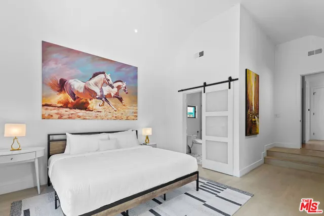 a bedroom with a bed and a wall painting