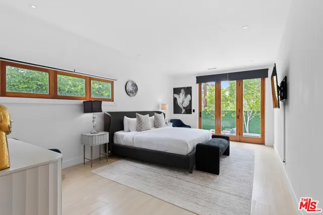 a bedroom with a bed and a large window