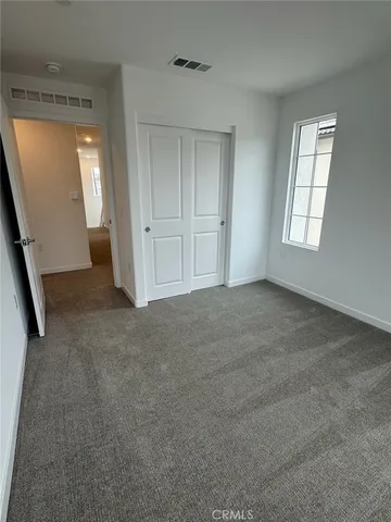 an empty room with windows and closet