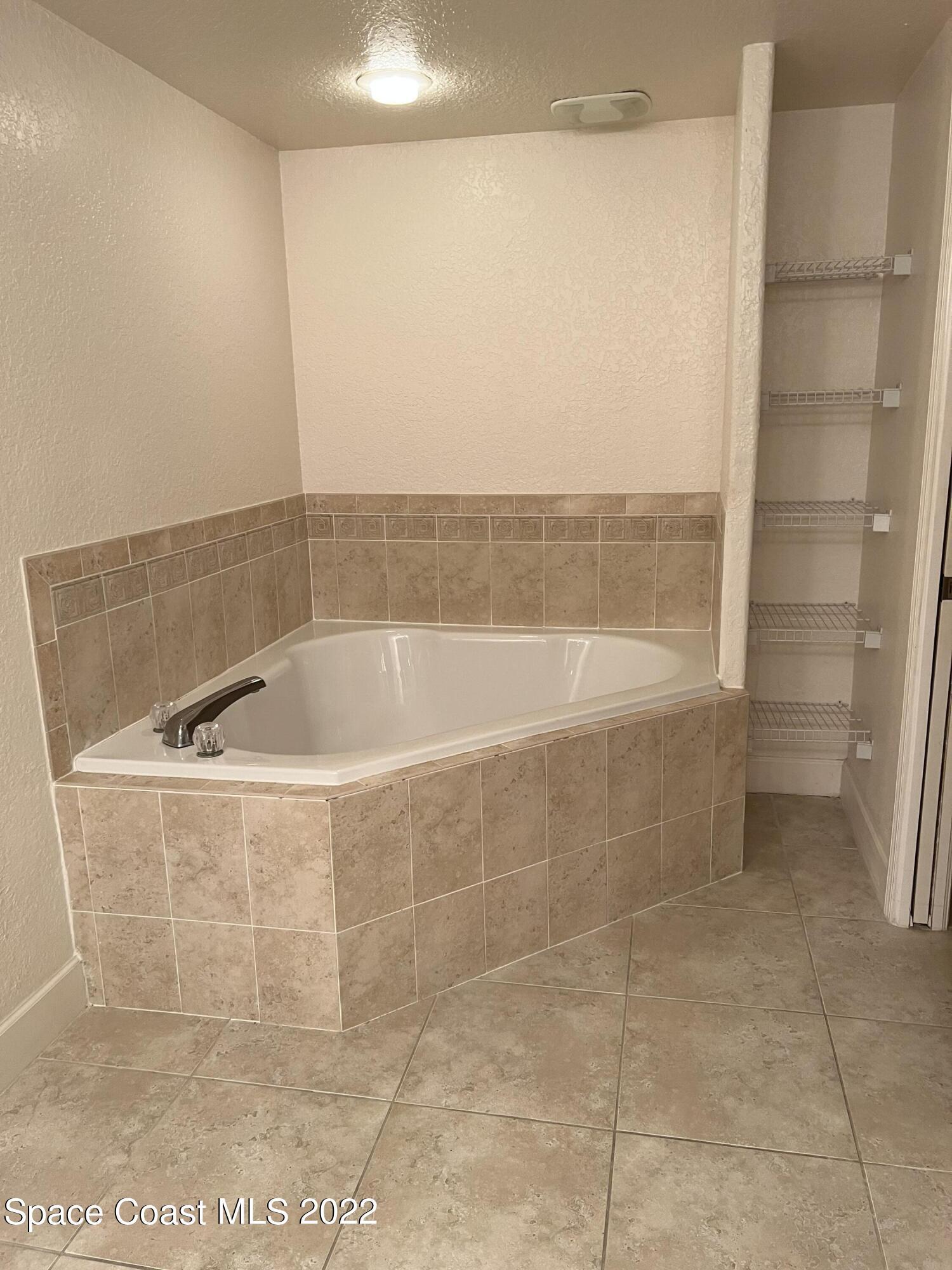817 Mystic Drive, Unit B410 Cape Canaveral, FL 32920 - Photo 12 of 28 a bath tub sitting next to a white sink