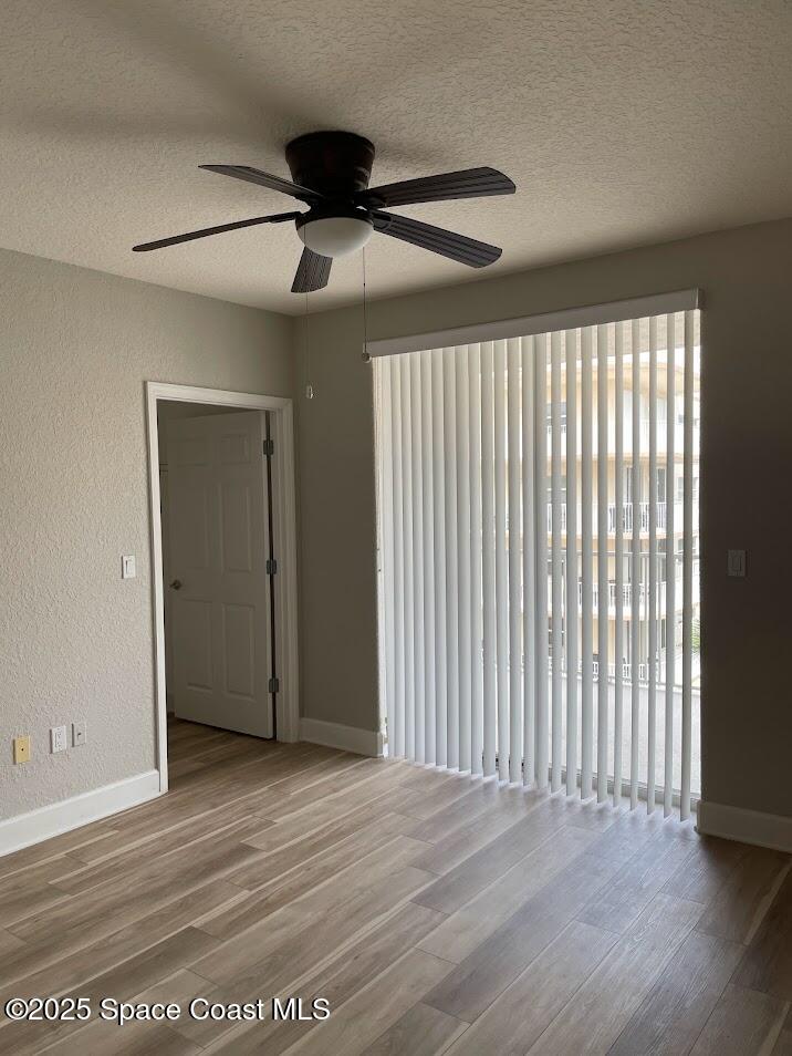 817 Mystic Drive, Unit B410 Cape Canaveral, FL 32920 - Photo 14 of 28 a view of an empty room with wooden floor and a window