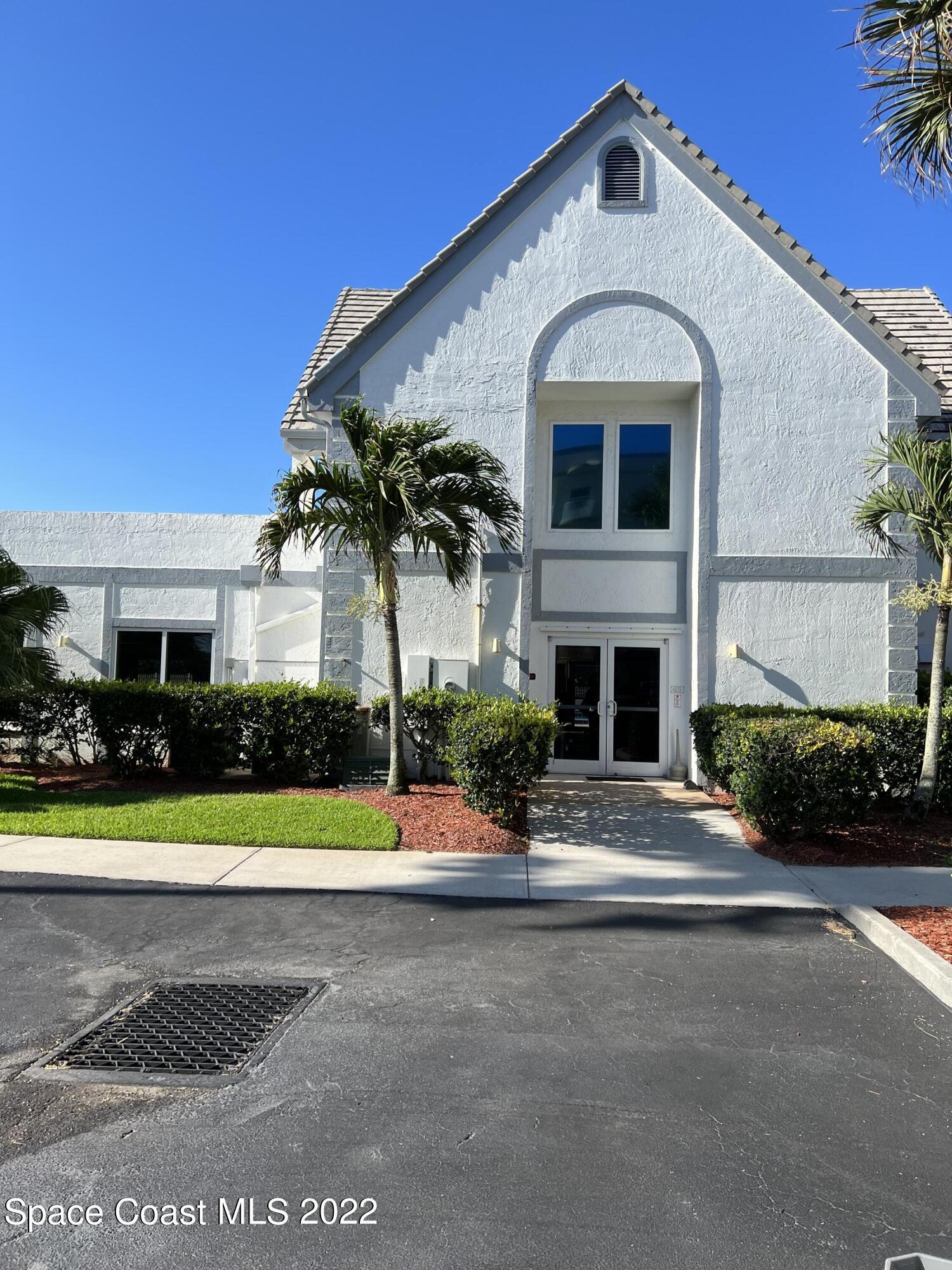 817 Mystic Drive, Unit B410 Cape Canaveral, FL 32920 - Photo 21 of 28 a front view of a house with a yard and garage