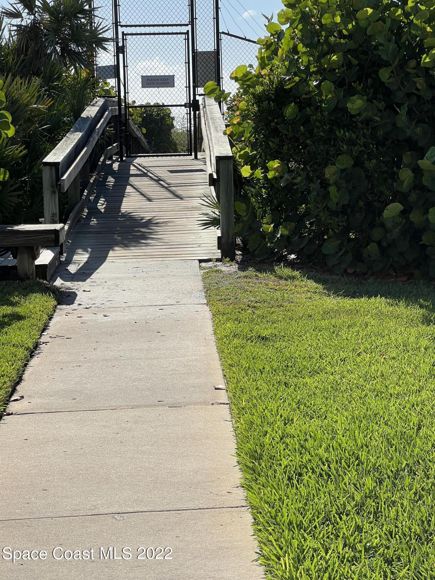 817 Mystic Drive, Unit B410 Cape Canaveral, FL 32920 - Photo 27 of 28 a view of a pathway with a yard
