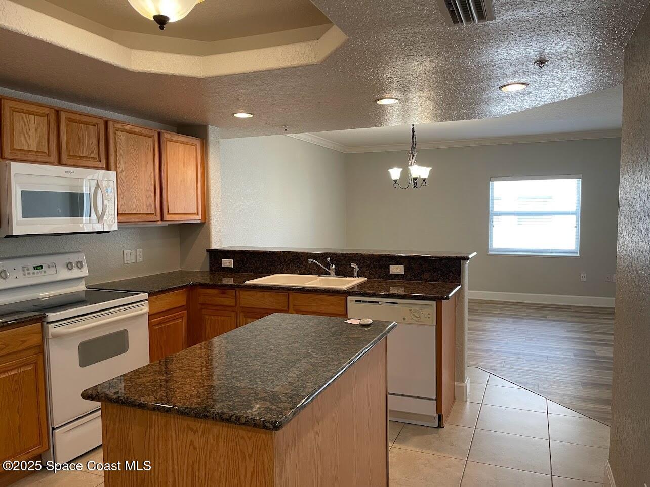 817 Mystic Drive, Unit B410 Cape Canaveral, FL 32920 - Photo 4 of 28 a kitchen with stainless steel appliances granite countertop a sink a stove and a microwave