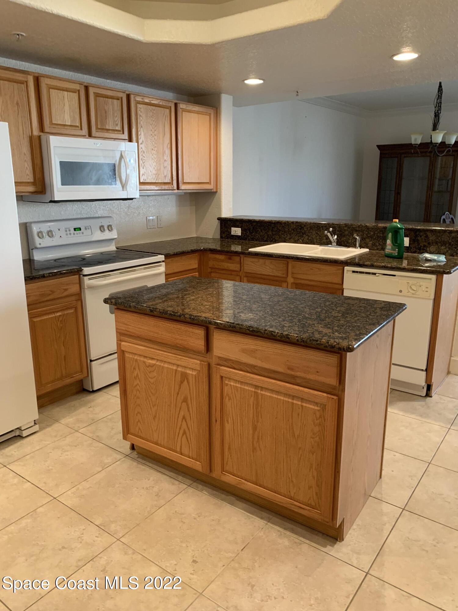 817 Mystic Drive, Unit B410 Cape Canaveral, FL 32920 - Photo 6 of 28 a kitchen with stainless steel appliances granite countertop a stove a sink and a microwave
