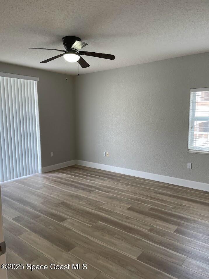 817 Mystic Drive, Unit B410 Cape Canaveral, FL 32920 - Photo 9 of 28 an empty room with wooden floor fan and windows