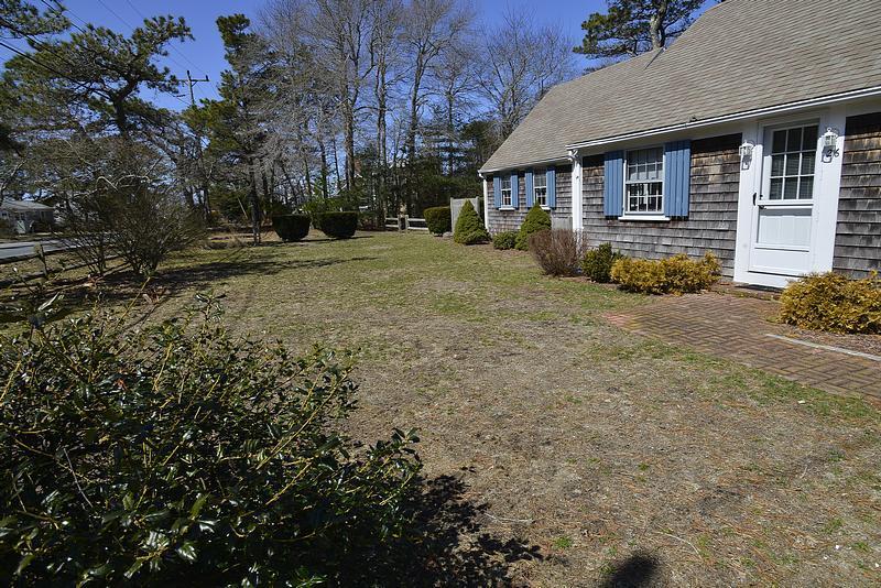 26 Lower County Road Dennis Port, MA 02639 - Photo 2 of 32 a front view of a house with a yard