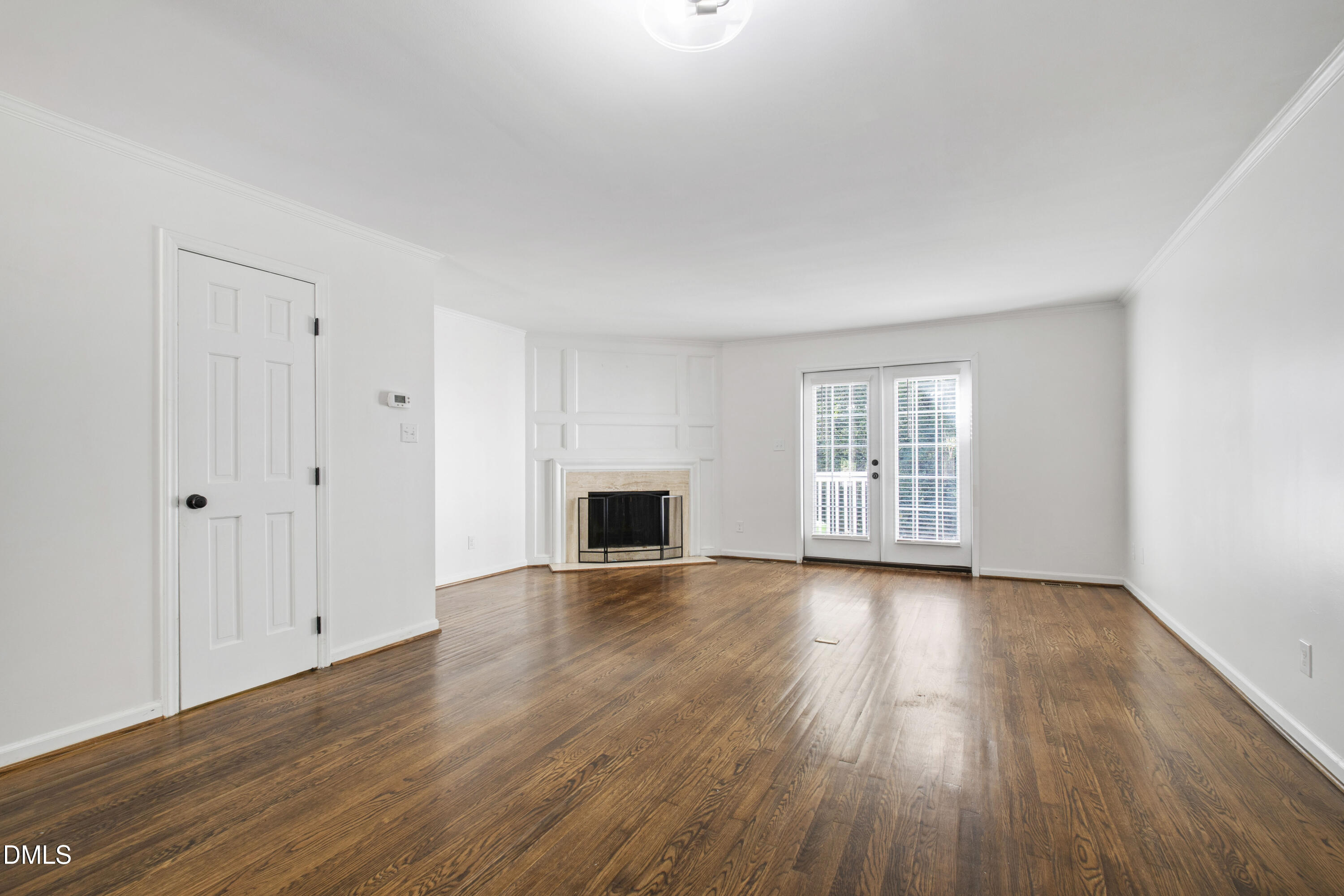 2824 Wayland Drive Raleigh, NC 27608 - Photo 13 of 31 a view of empty room with wooden floor and fireplace