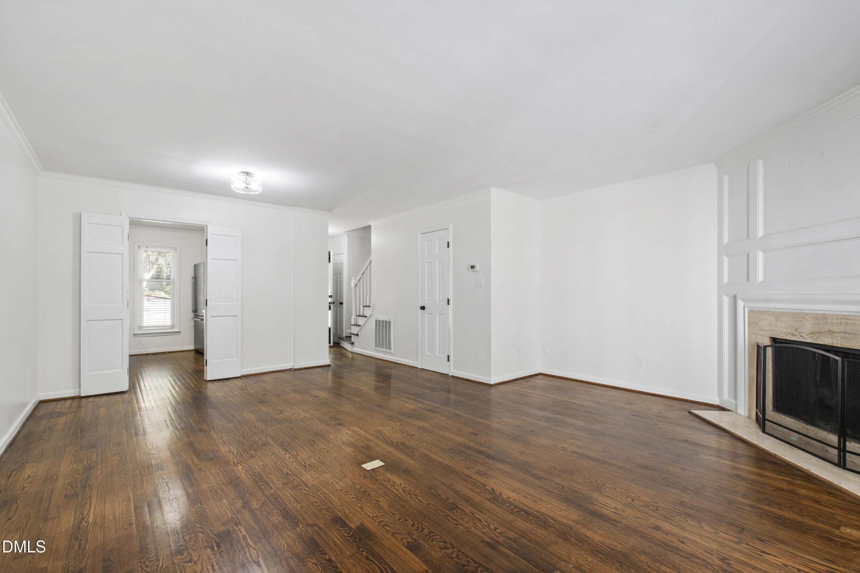 2824 Wayland Drive Raleigh, NC 27608 - Photo 14 of 31 a view of an empty room with wooden floor fireplace and a window