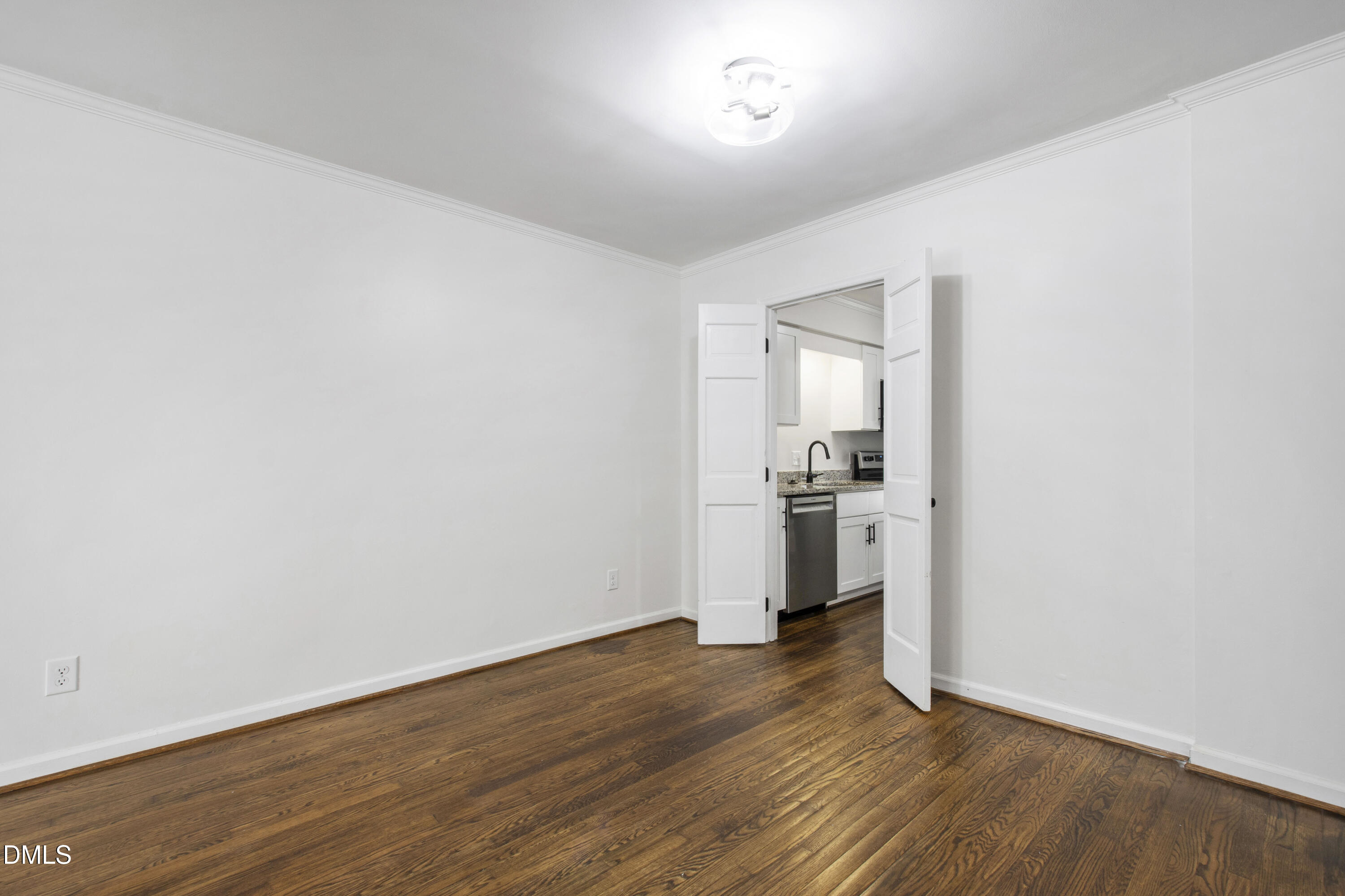 2824 Wayland Drive Raleigh, NC 27608 - Photo 17 of 31 an empty room with wooden floor and a kitchen