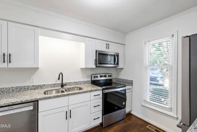 a kitchen with stainless steel appliances granite countertop a sink stove and microwave