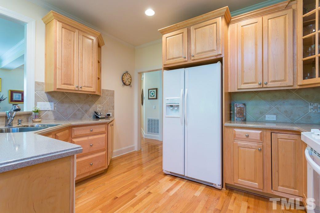 7260 Summit Waters Lane Raleigh, NC 27613 - Photo 8 of 23 a kitchen with granite countertop wooden cabinets and a refrigerator