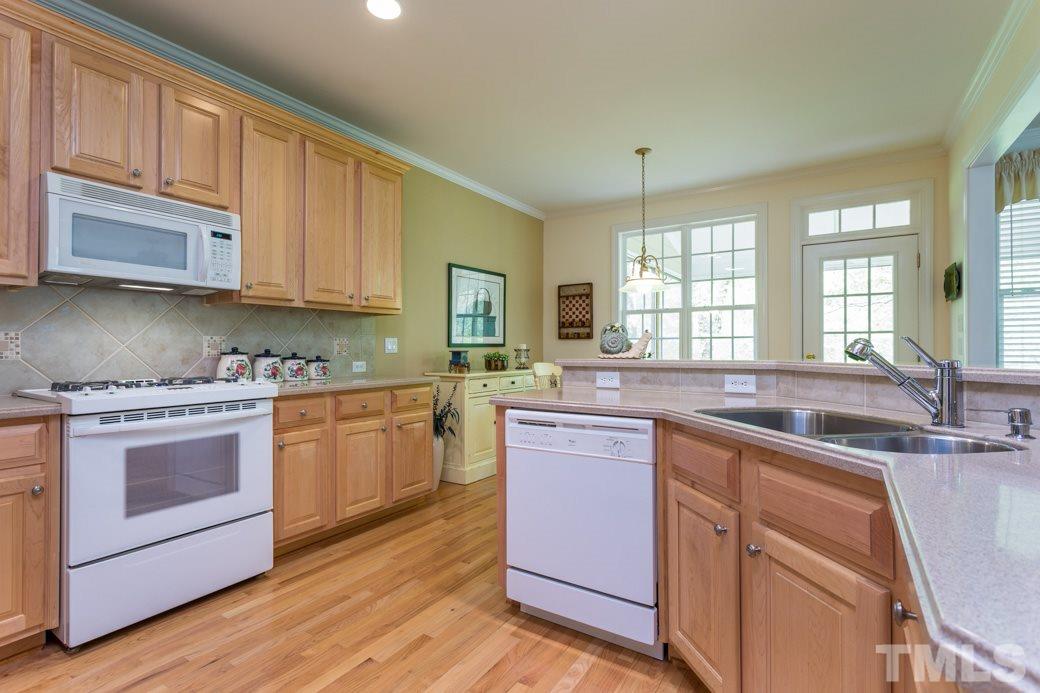 7260 Summit Waters Lane Raleigh, NC 27613 - Photo 9 of 23 a kitchen with granite countertop a sink stainless steel appliances and cabinets