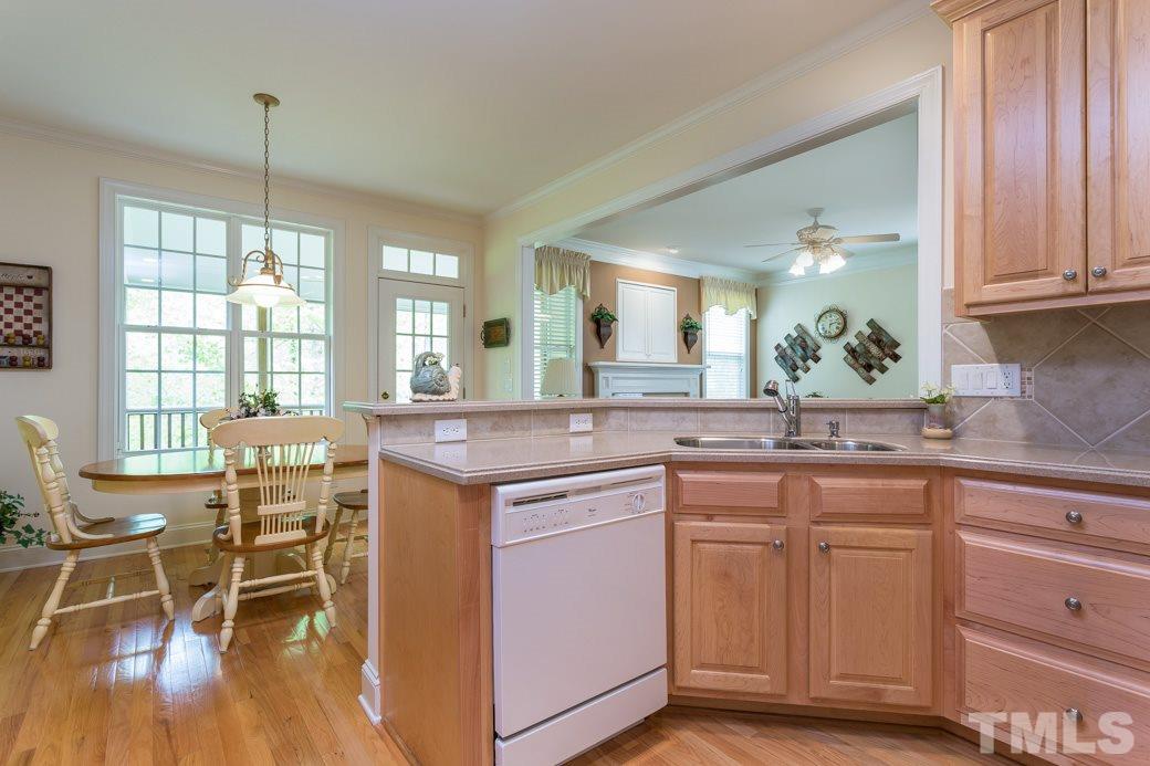 7260 Summit Waters Lane Raleigh, NC 27613 - Photo 10 of 23 a kitchen with kitchen island granite countertop a table chairs stove and sink