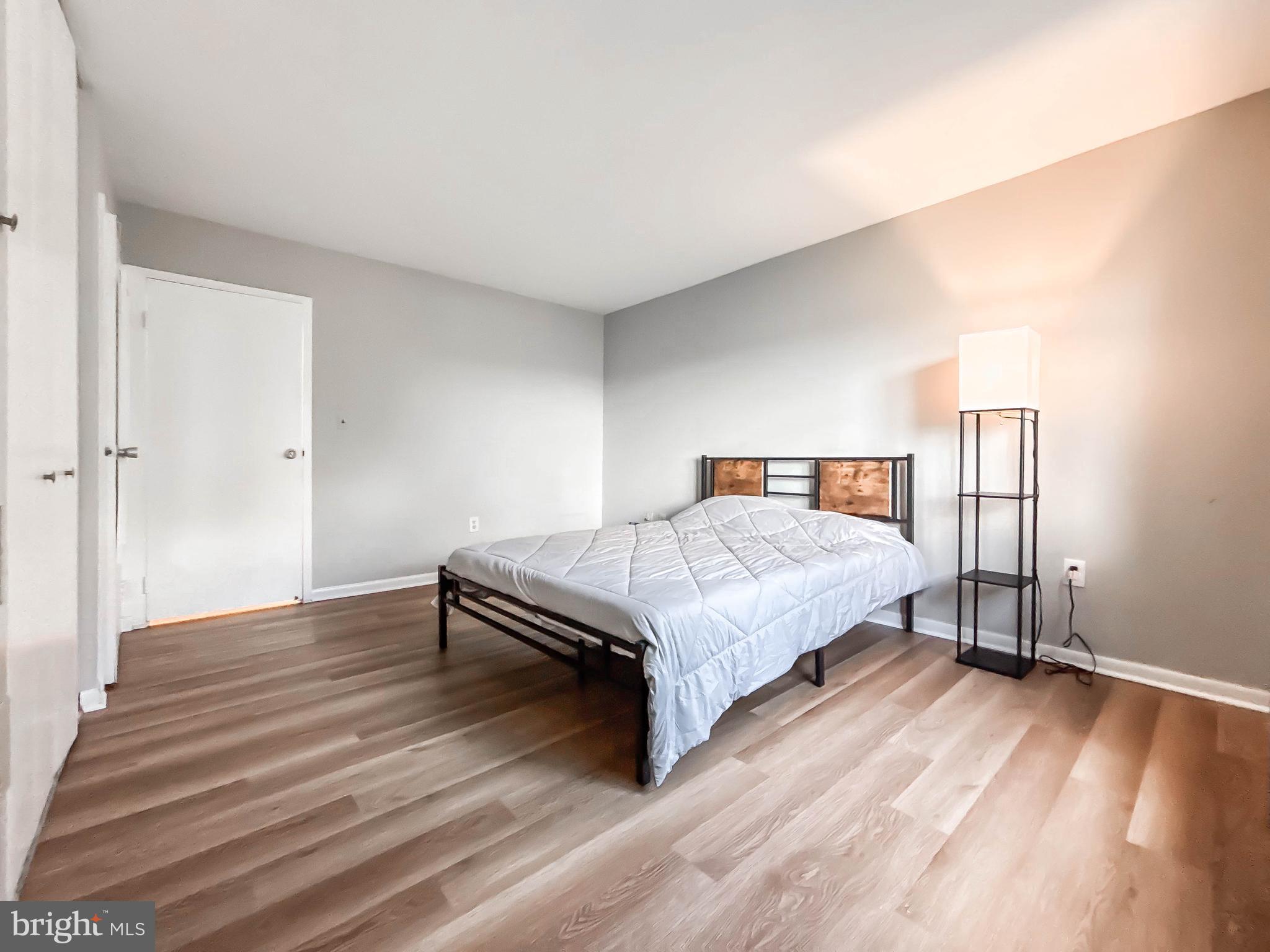 130 Slade Avenue, Unit 414 Baltimore, MD 21208 - Photo 19 of 48 a bedroom with a bed and wooden floor