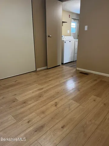 a view of a hallway with wooden floor and windows