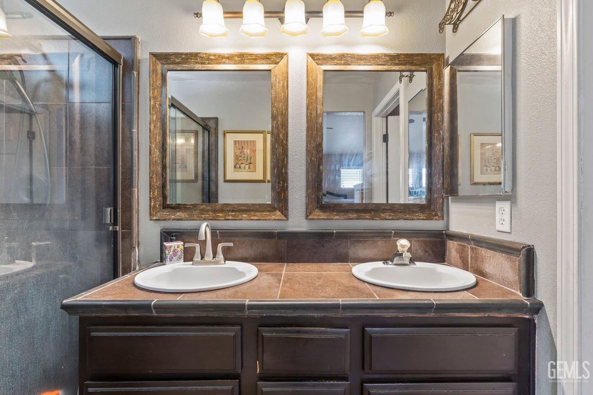 Undisclosed Address Bakersfield, CA 93312 - Photo 14 of 31 a bathroom with a sink double vanity and a mirror