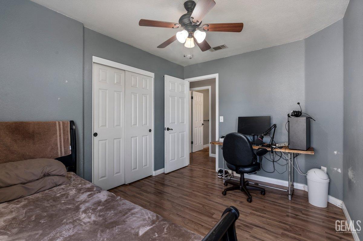 Undisclosed Address Bakersfield, CA 93312 - Photo 18 of 31 a workspace with wooden floor and a chandelier fan