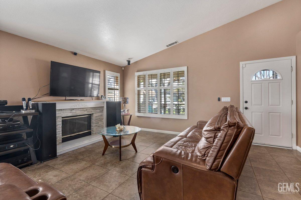 Undisclosed Address Bakersfield, CA 93312 - Photo 19 of 31 a living room with furniture a flat screen tv and a fireplace