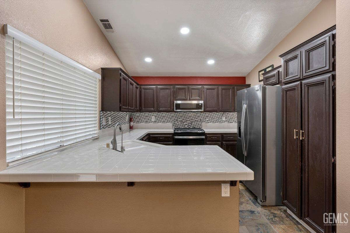 Undisclosed Address Bakersfield, CA 93312 - Photo 23 of 31 a kitchen with stainless steel appliances a sink stove and refrigerator