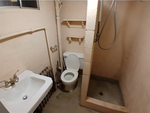 a bathroom with a sink a toilet and shower