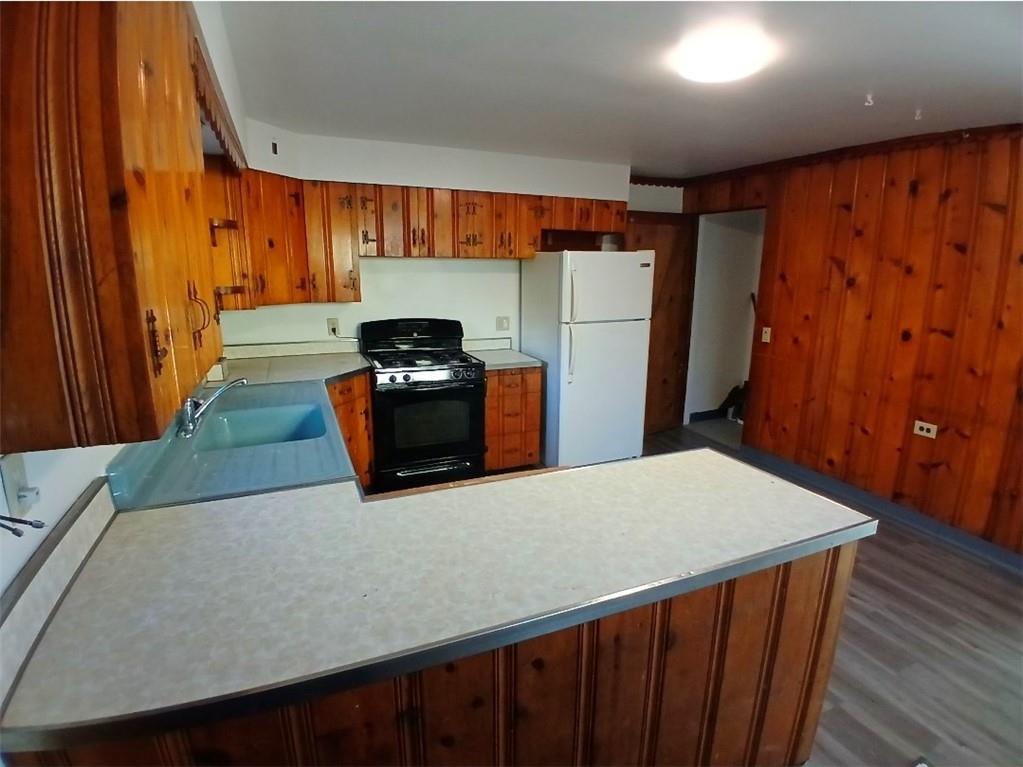 231 Rinne Street Pittsburgh, PA 15210 - Photo 7 of 24 a kitchen with stainless steel appliances kitchen island granite countertop a refrigerator and a stove