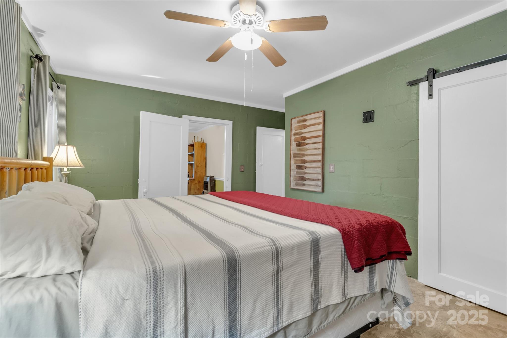 3605 Skyuka Mountain Road Columbus, NC 28722 - Photo 13 of 46 a bedroom with a large bed and a chandelier