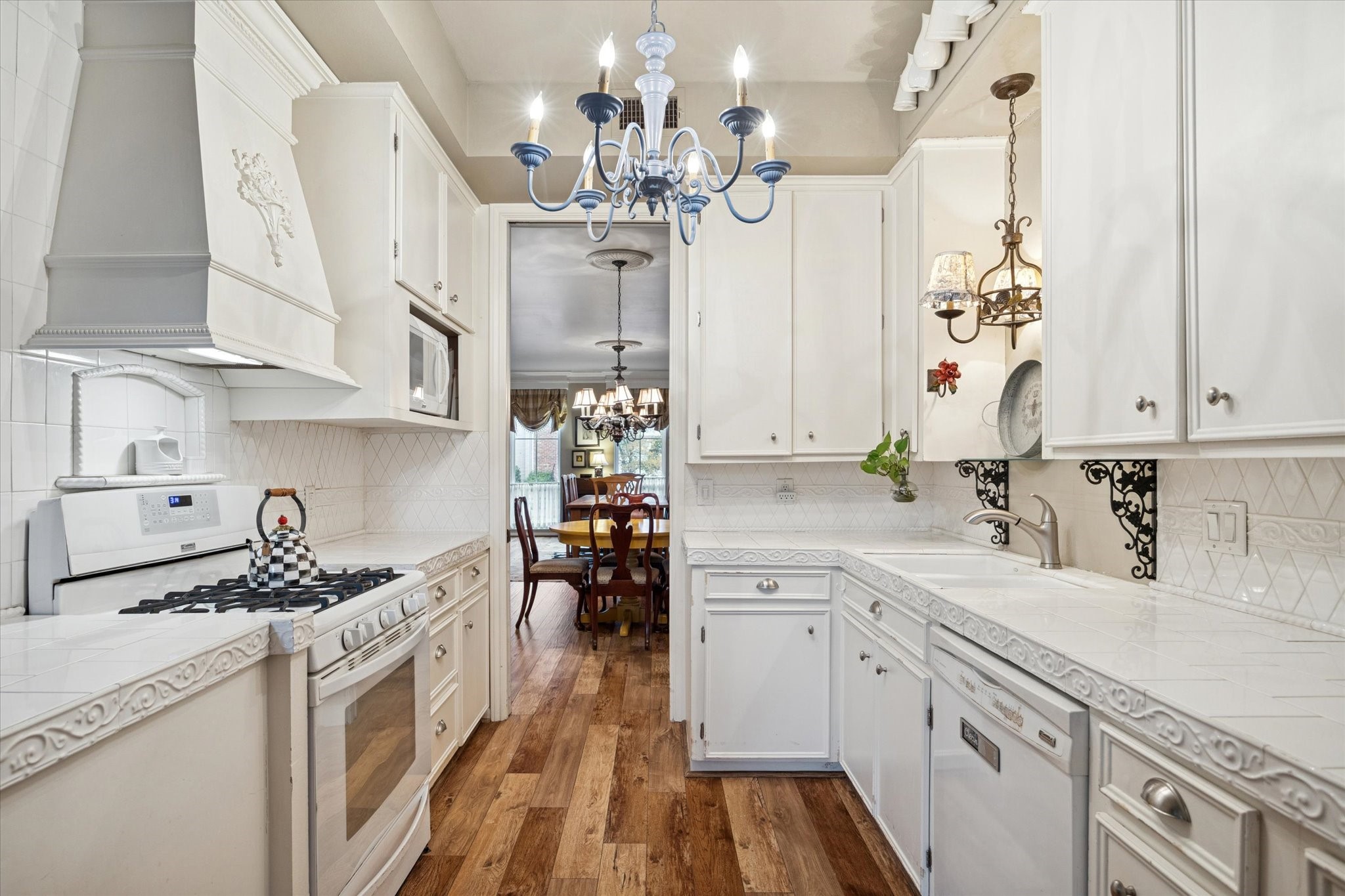 7525 Del Monte Drive Houston, TX 77063 - Photo 11 of 30 a kitchen with cabinets a sink dishwasher and a stove with wooden floor