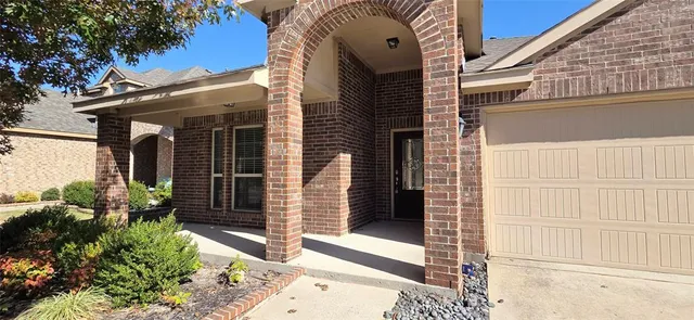 a view of a house with a potted plant and a garage