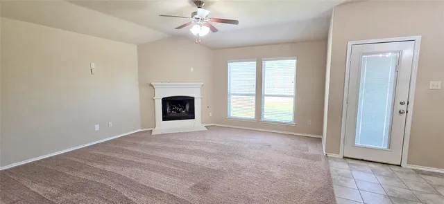 an empty room with windows and fireplace