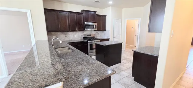 a kitchen with a sink stove and microwave