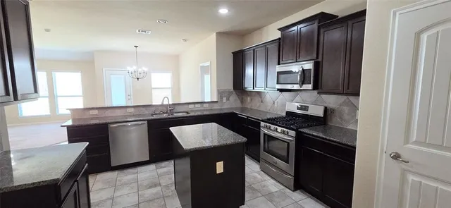 an empty room with windows and fireplace
