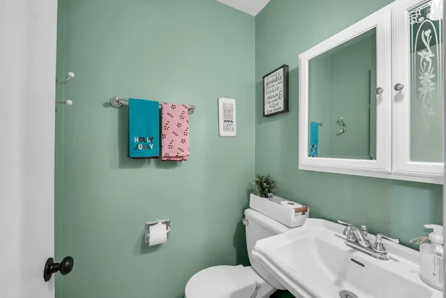 a bathroom with a toilet sink and mirror