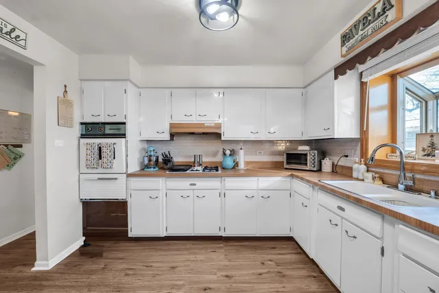 a kitchen with cabinets stainless steel appliances a sink and a window