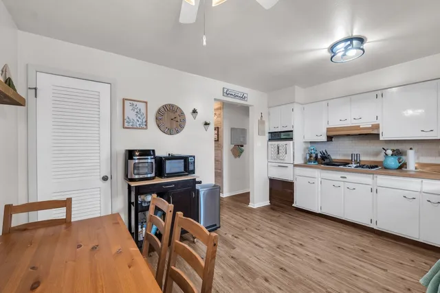 a kitchen with stainless steel appliances granite countertop a stove top oven a refrigerator a sink and dishwasher with wooden floor