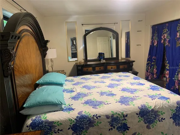 a bedroom with a bed and a mirror